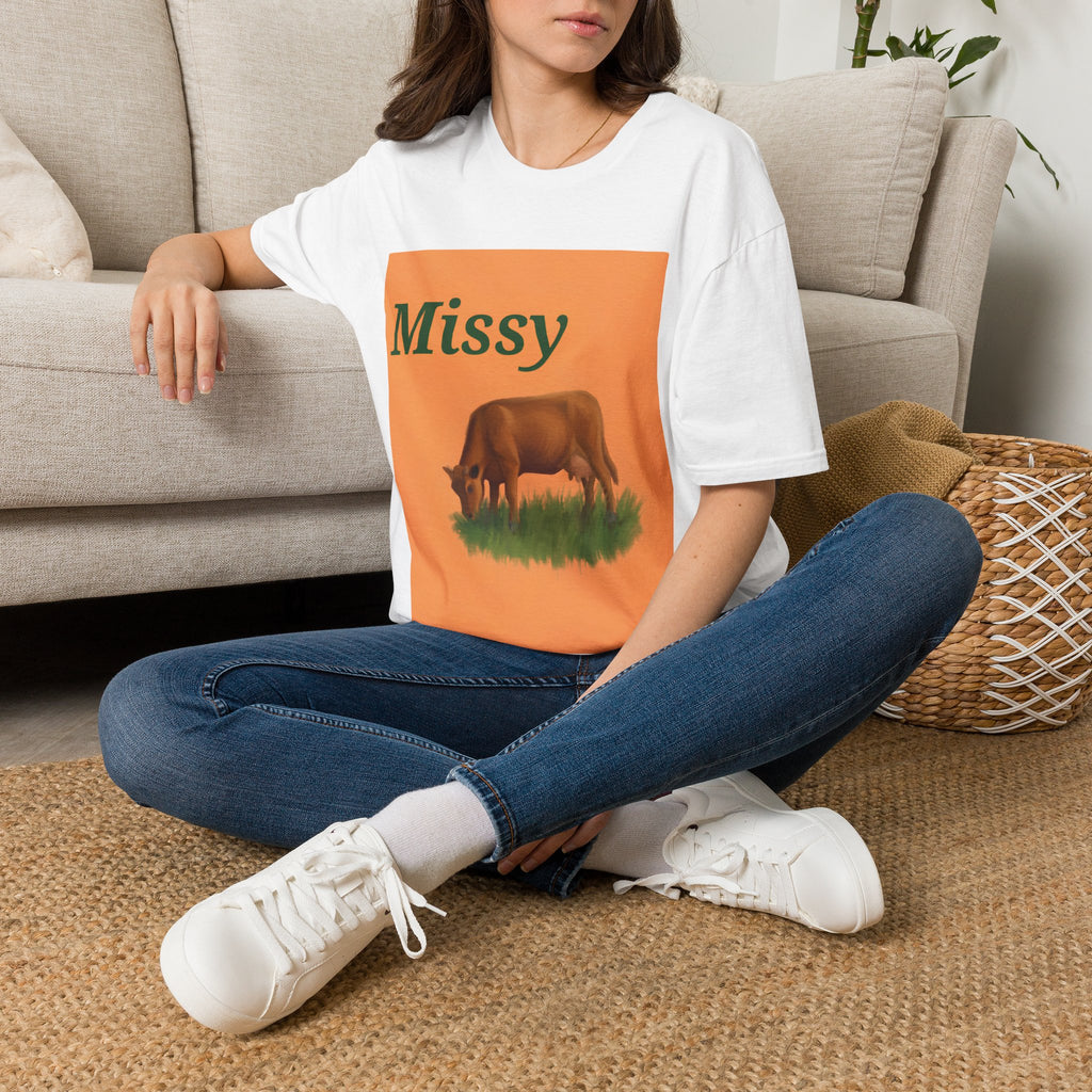 White crewneck T-shirt on model, orange “Missy” grazing cow graphic panel