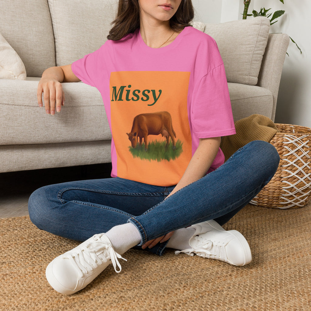 Pink cow graphic t-shirt with orange front print and grazing cow artwork