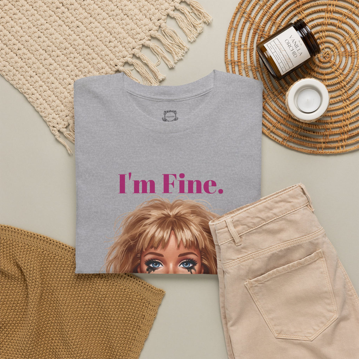Heather gray crewneck T-shirt laid flat with doll face graphic and “I’m Fine.” text
