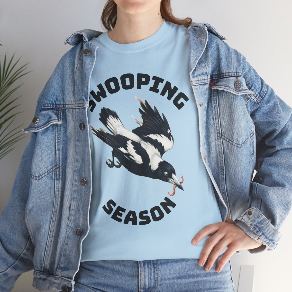 Light blue t-shirt with bird graphic and bold text; close-up of print