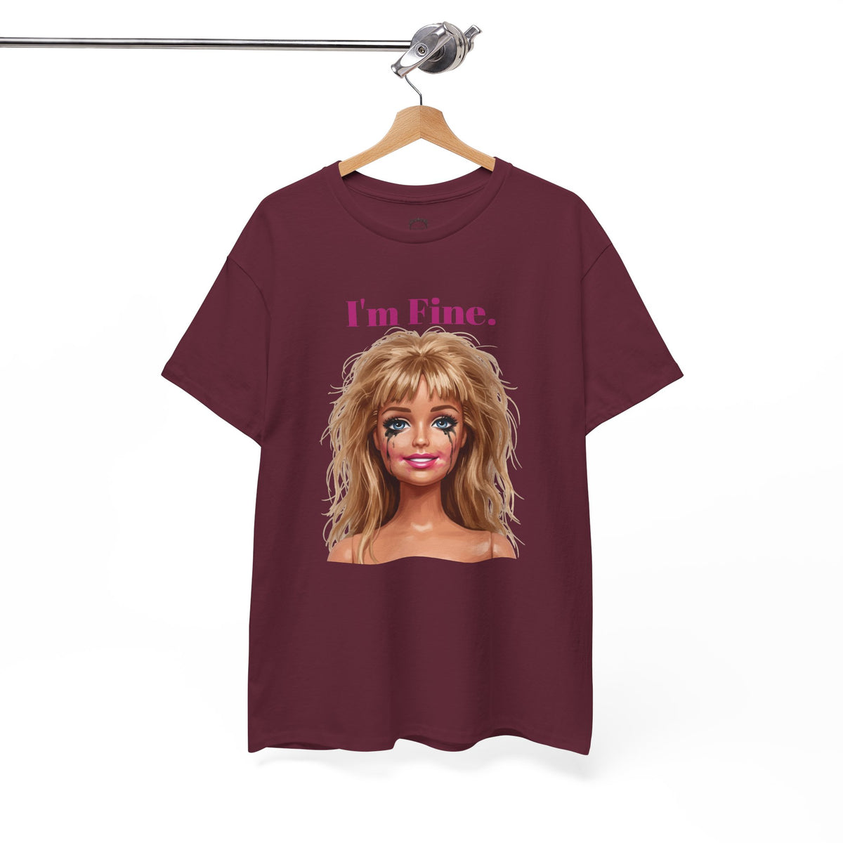 Maroon crewneck T-shirt with doll face graphic and “I’m Fine.” text, hanging on hanger