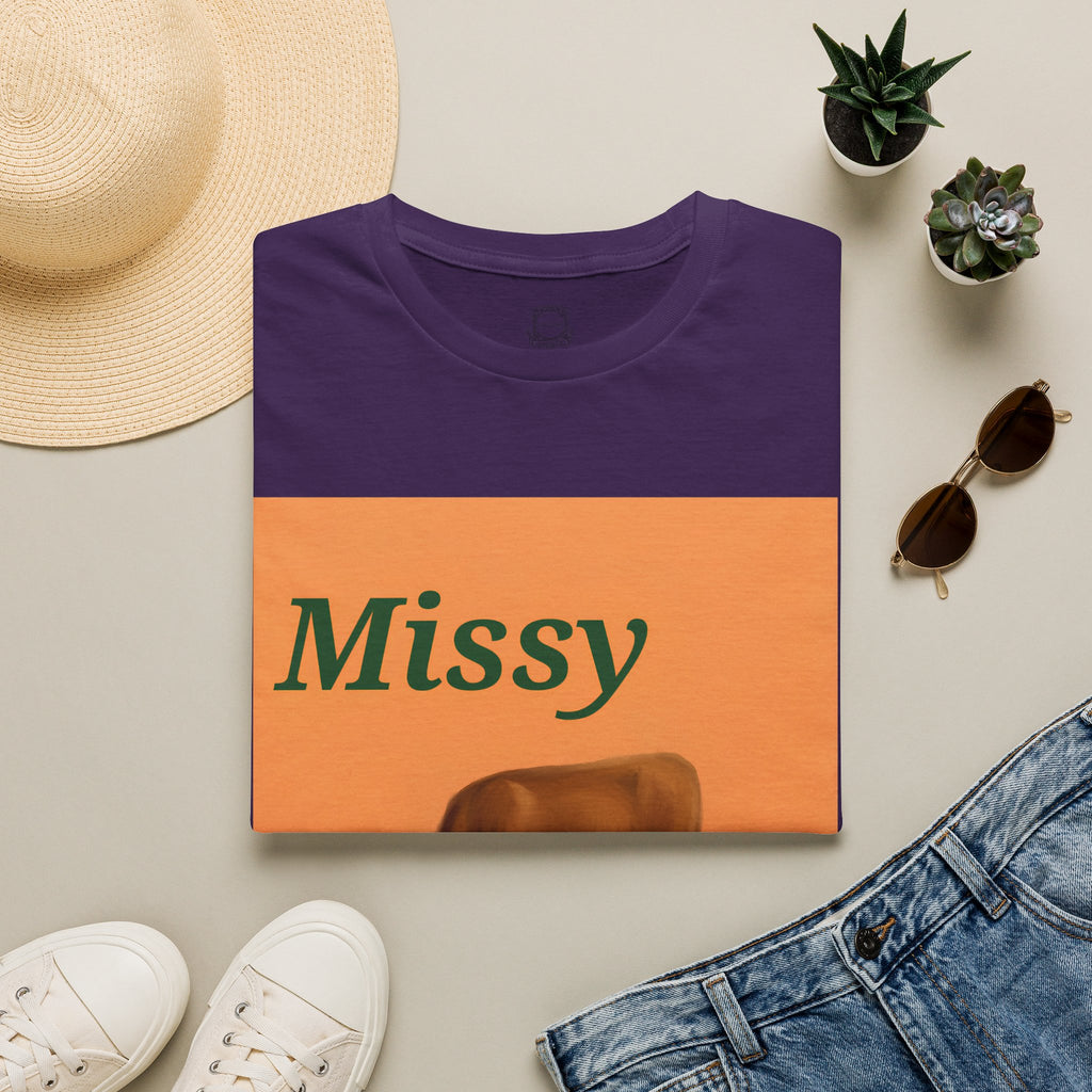 Purple crew-neck T-shirt with orange Missy text and grazing cow graphic