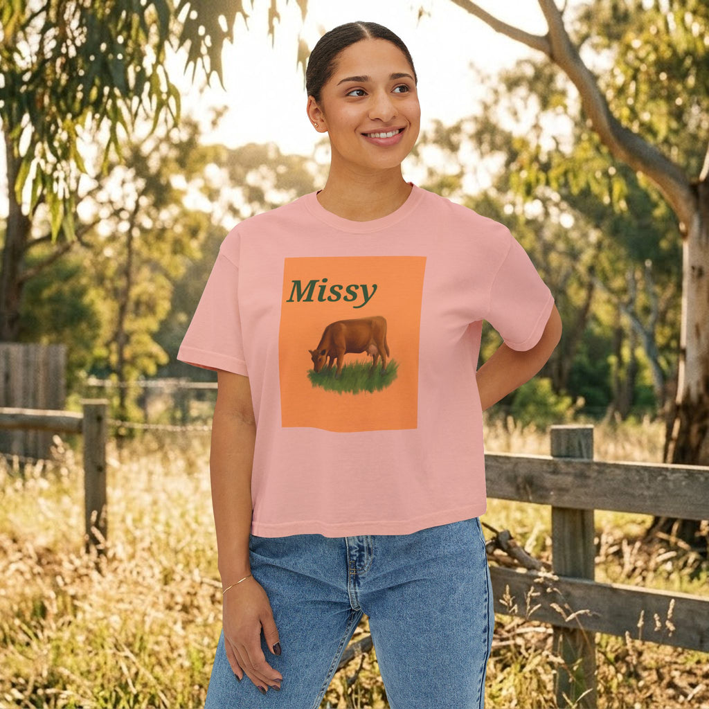 Women’s boxy tee in peach pink with “Missy” cow graphic on the front.