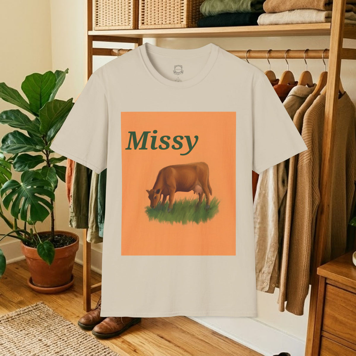 Cream crew-neck t-shirt with orange square “Missy” grazing cow graphic