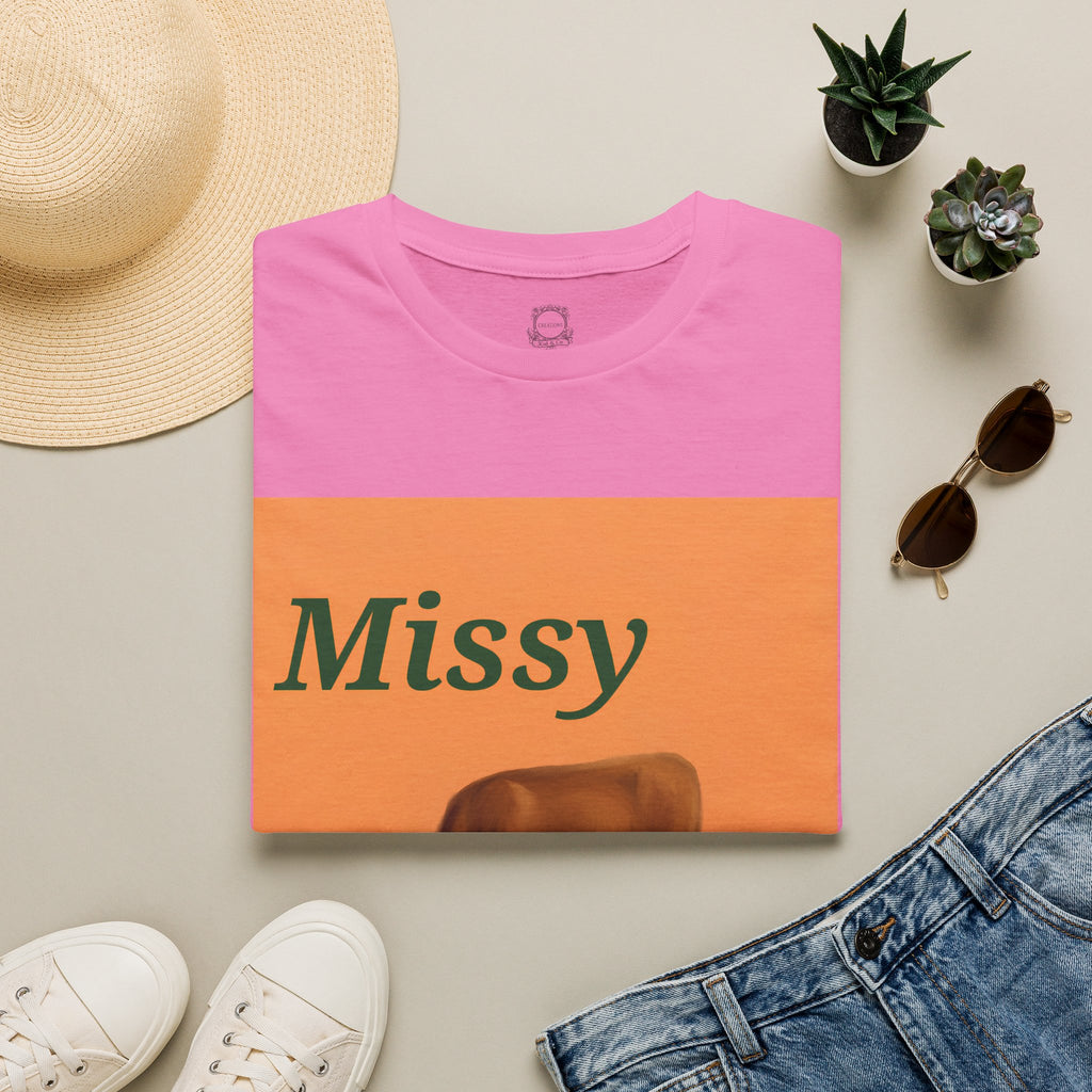 Pink cow graphic t-shirt with orange panel, Missy text, and grazing cow