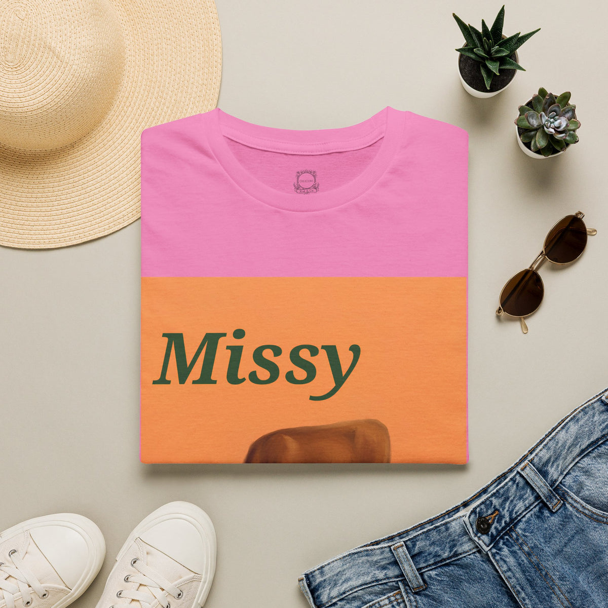 Pink cow graphic t-shirt with orange panel, Missy text, and grazing cow