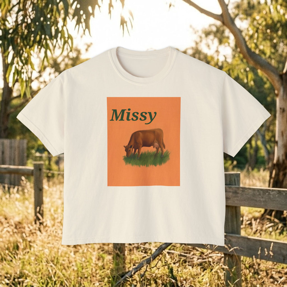 Cream boxy T-shirt with orange square cow graphic and “Missy” text on front.