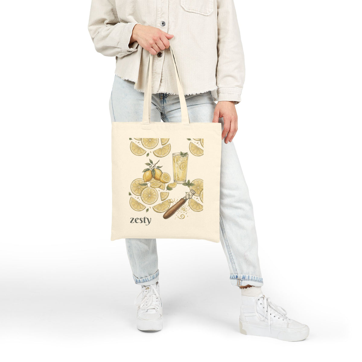 Natural tote bag with zesty lemon citrus illustration, held at side by top handles