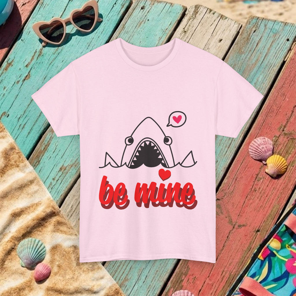Light pink T-shirt laid flat with cartoon shark and red “be mine” graphic