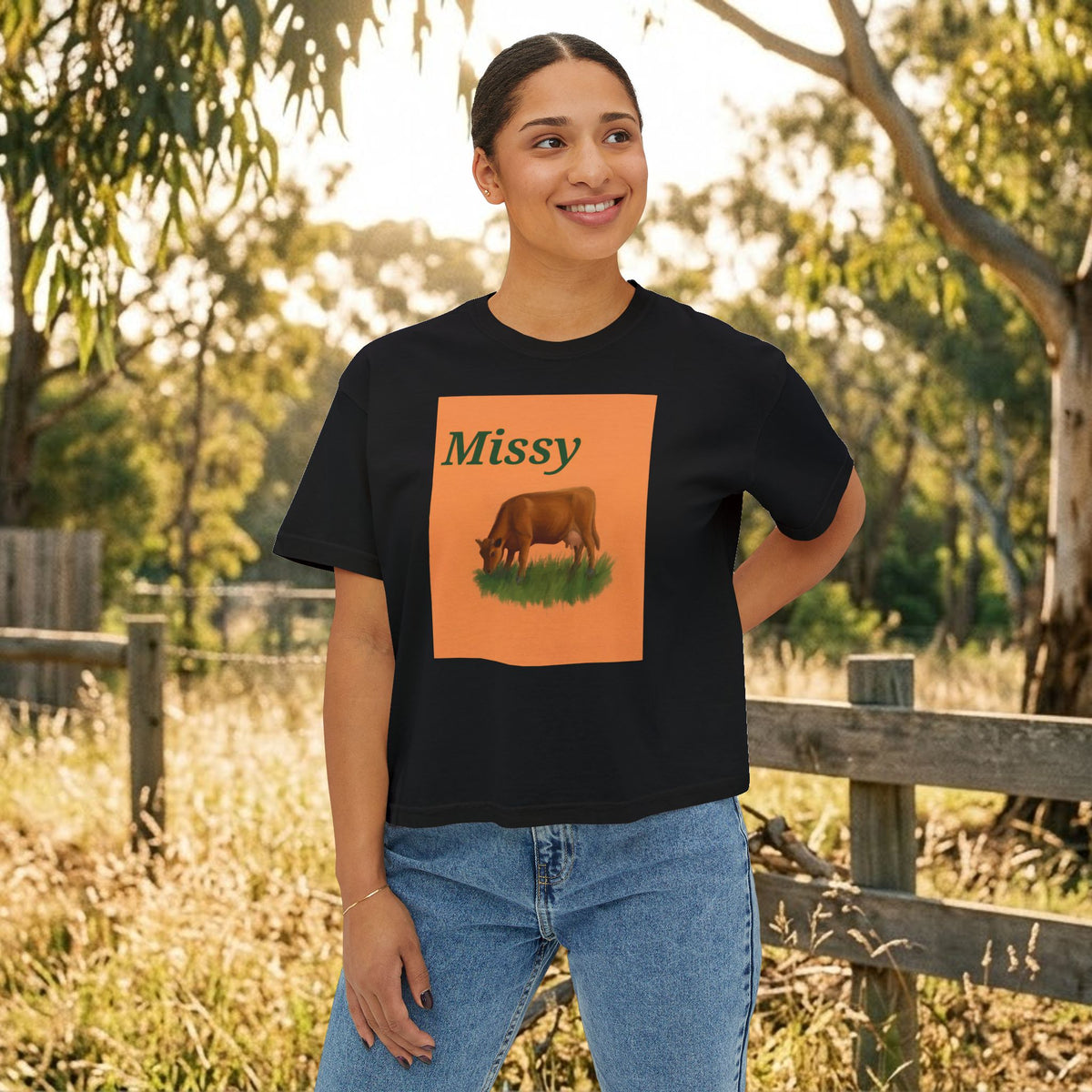 Black boxy T-shirt with orange cow graphic and “Missy” text on the chest.