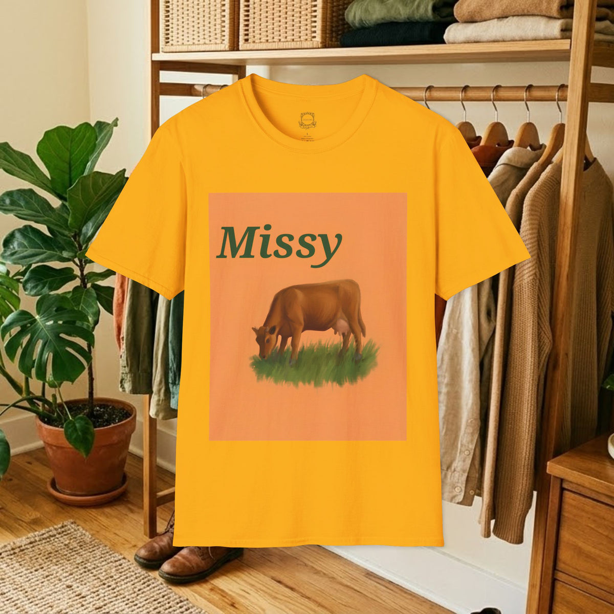 Gold short-sleeve T-shirt with orange “Missy” cow graphic on front