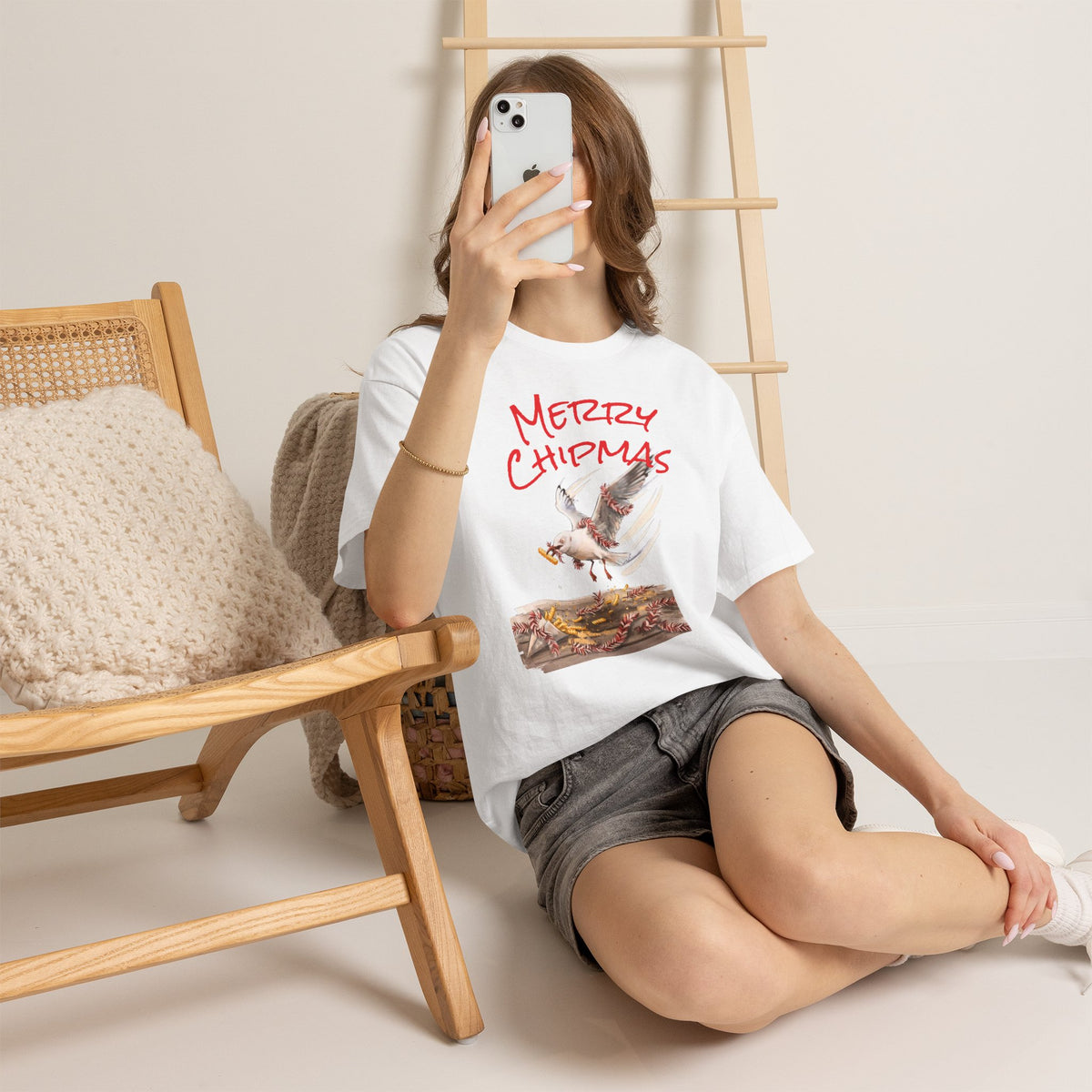 White crewneck tee with red “Merry Chipmas” seagull illustration, worn with shorts