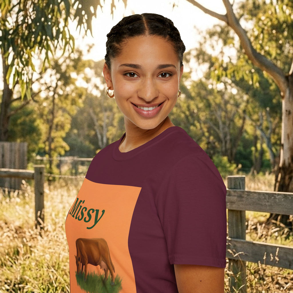 Maroon crewneck T-shirt on model with orange panel showing “Missy” and grazing cow