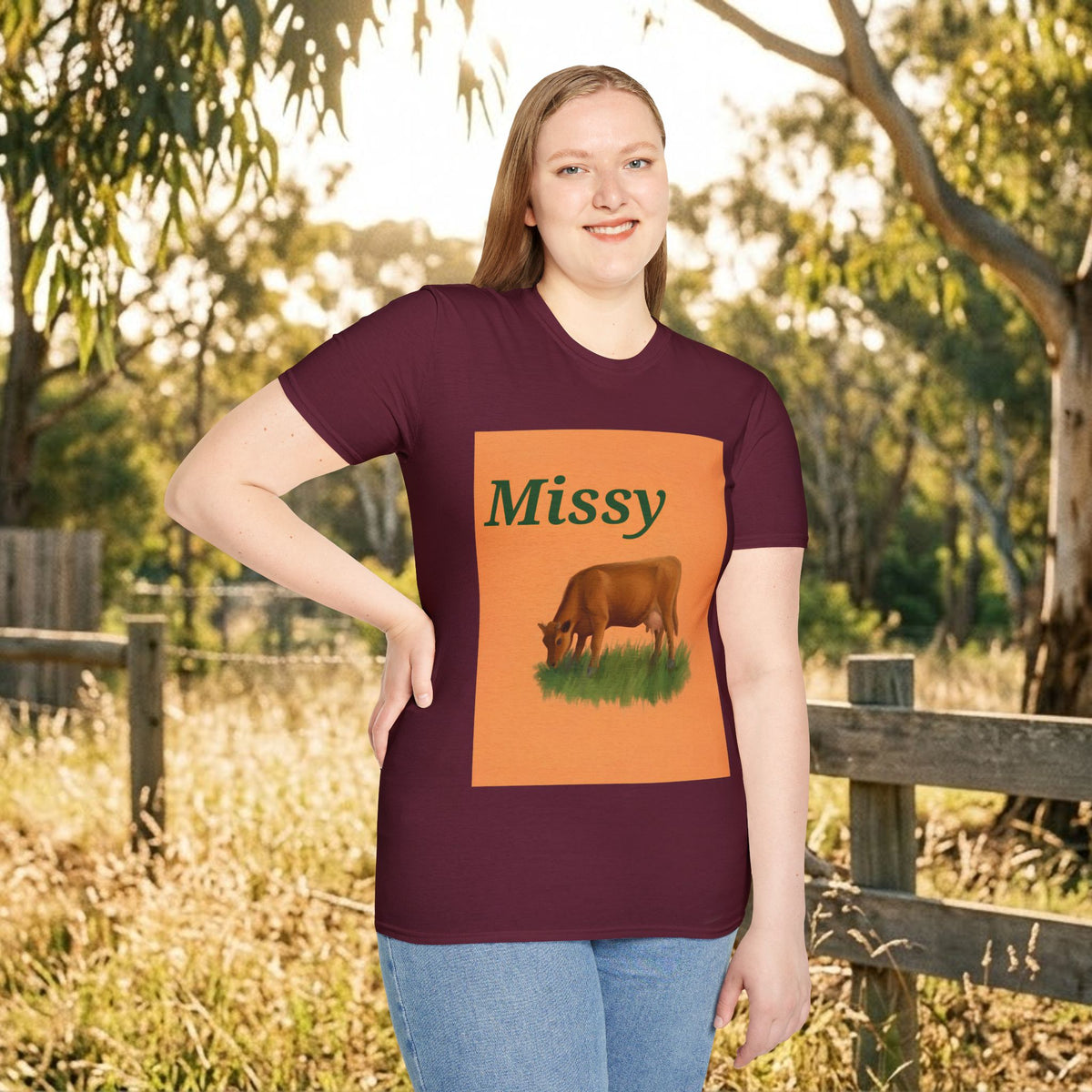 Maroon crewneck T-shirt on model with orange “Missy” panel and brown grazing cow