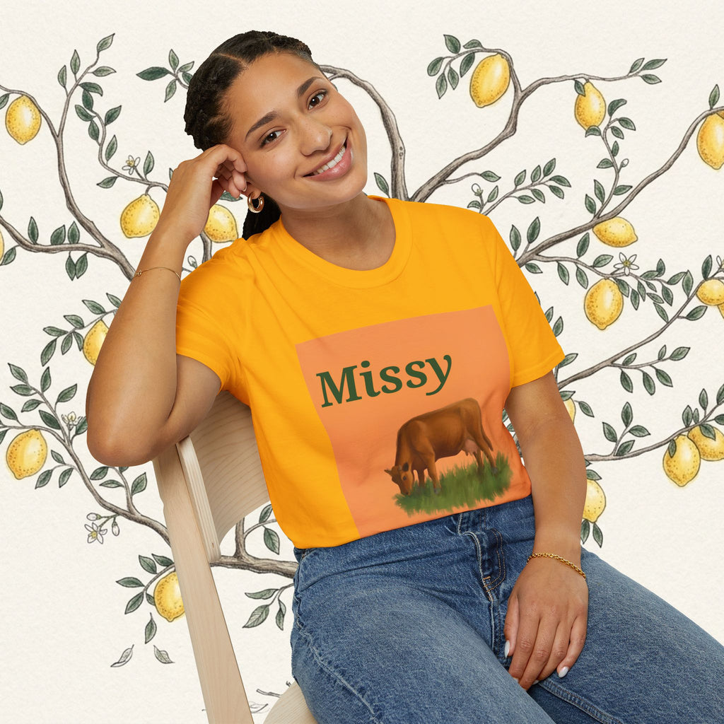 Orange Missy cow graphic T-shirt on model leaning on chair