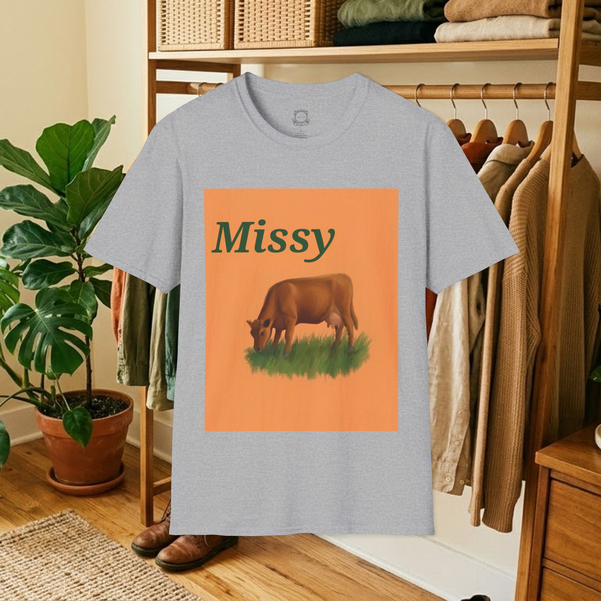 Light gray crew-neck t-shirt with orange square “Missy” grazing cow graphic