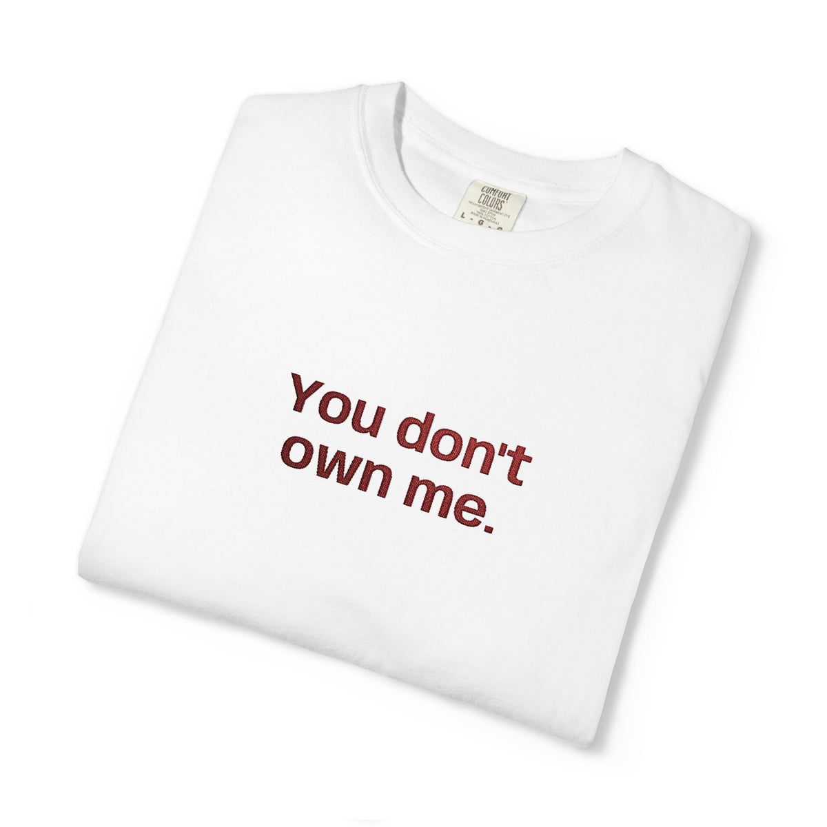 White folded T-shirt with "You don't own me." slogan printed across the front.