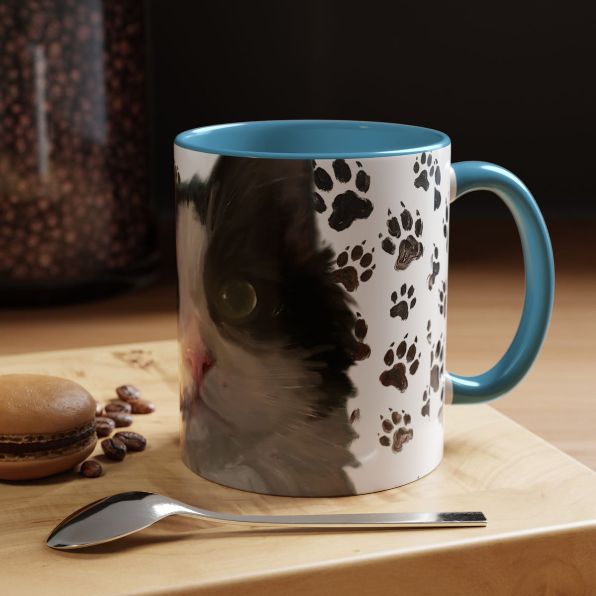 Black cat face accent coffee mug with paw print pattern, white body, light blue handle