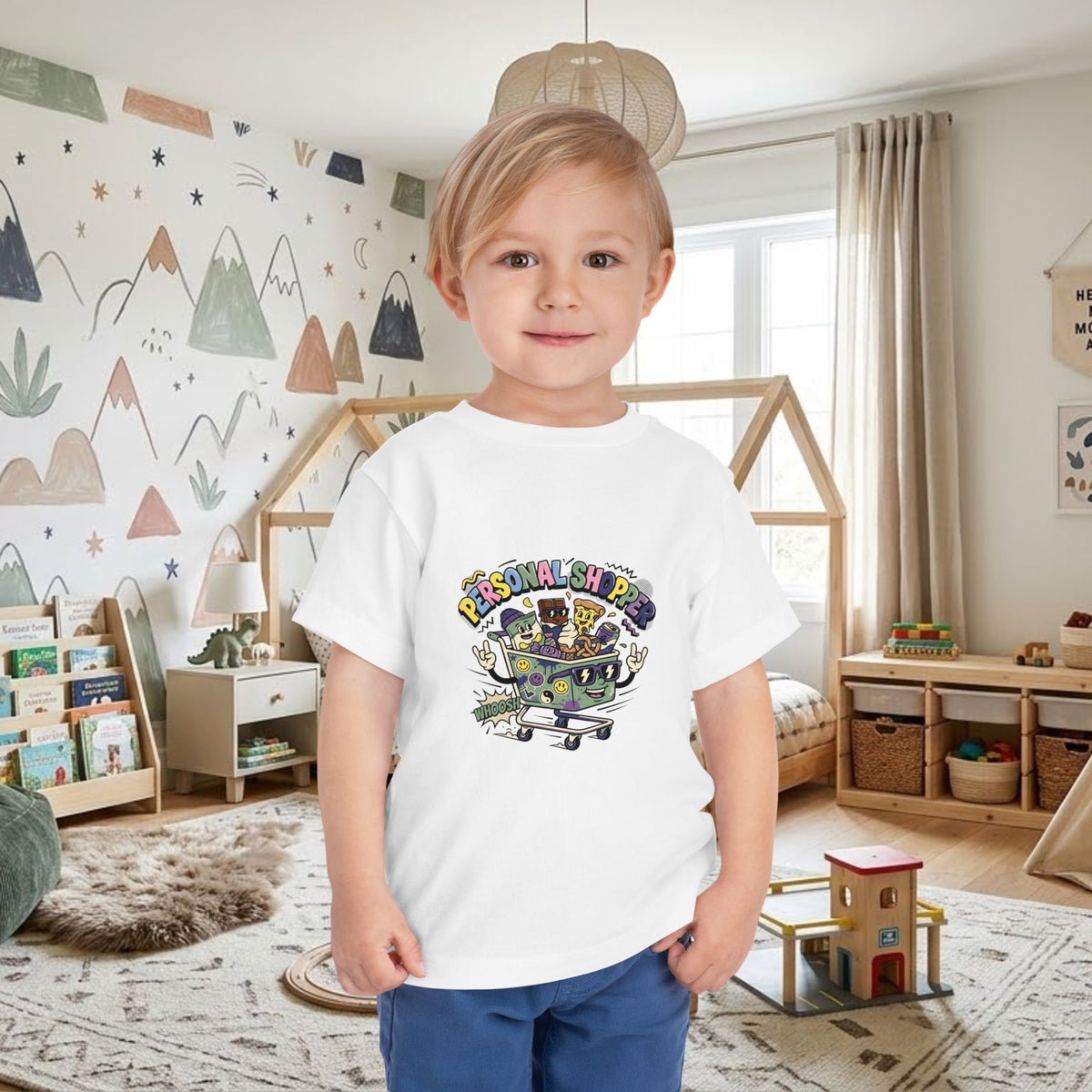 White toddler tee worn by a child, featuring a colorful shopping cart graphic