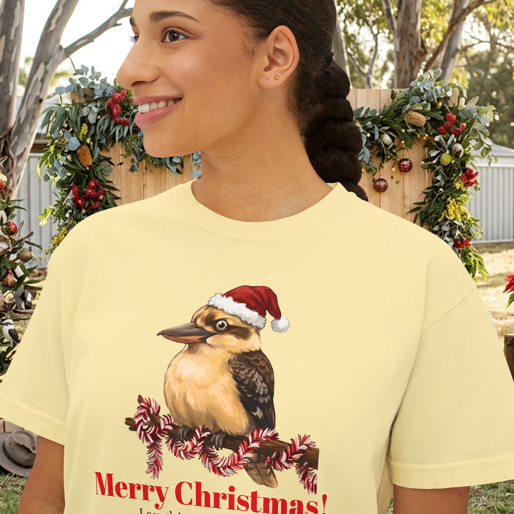 Light yellow t-shirt close-up: Santa-hat bird graphic with “Merry Christmas” text