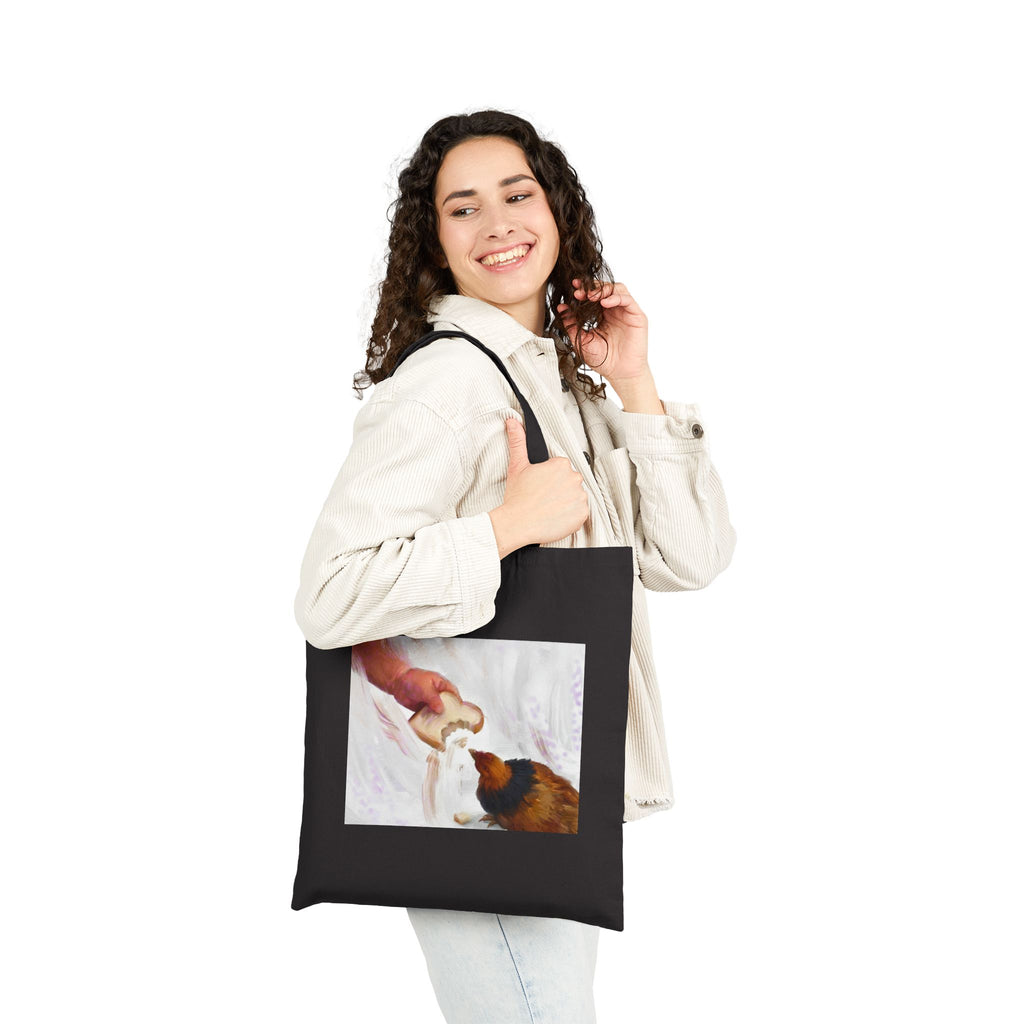 Black canvas tote bag with front hen-feeding illustration panel and two handles
