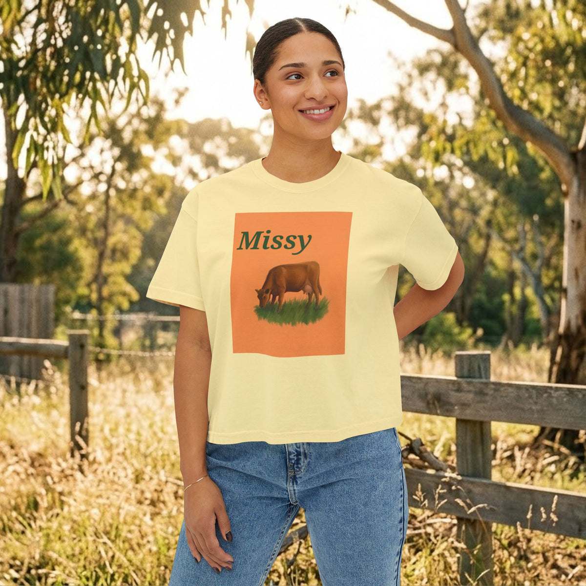 Women’s boxy graphic tee in butter yellow with 'Missy' cow illustration on front