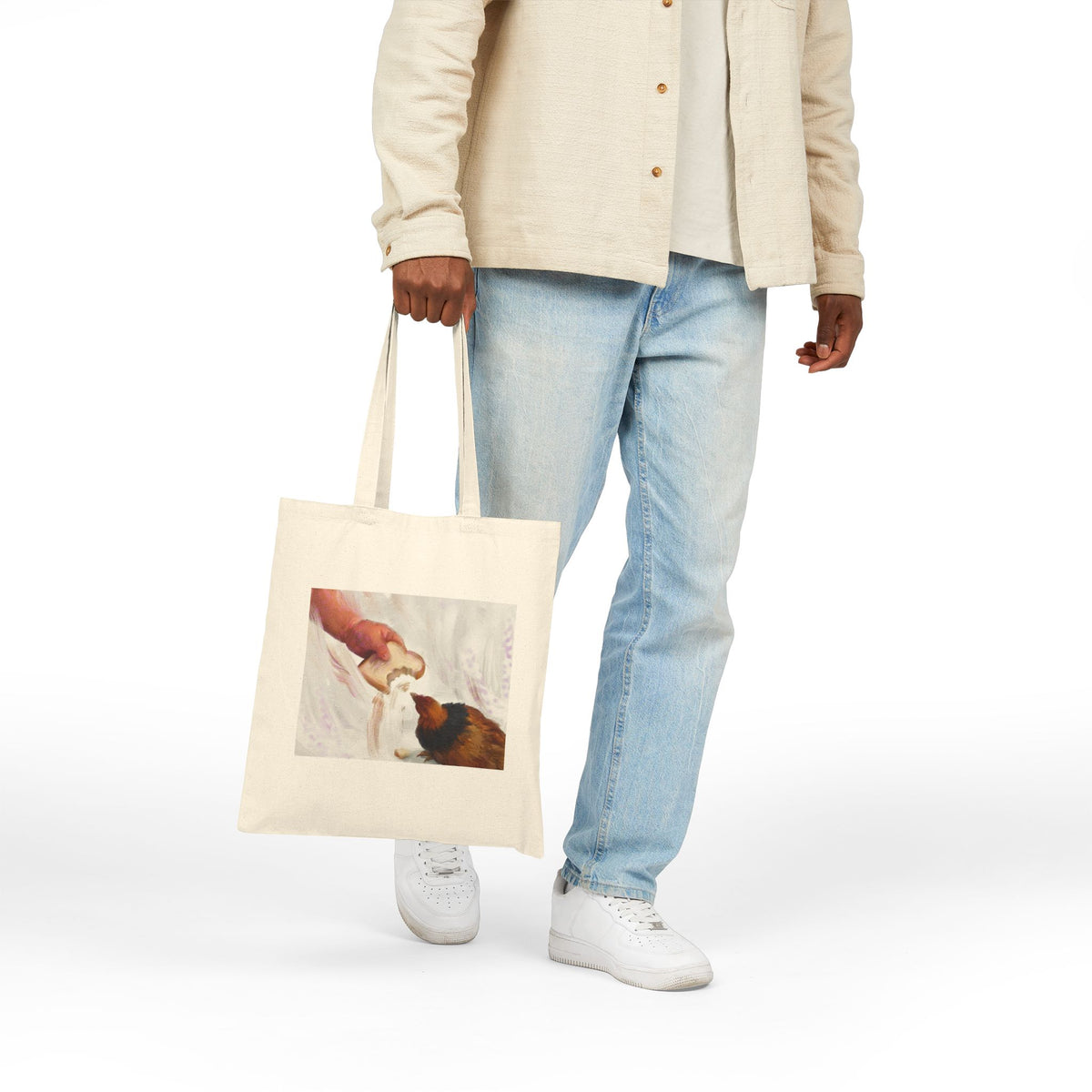 Natural canvas tote bag with vintage hen feeding illustration, held by hand.