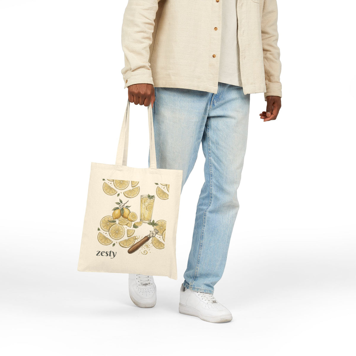 Natural tote bag held by handles, showing zesty lemon citrus illustration