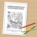 Printed Aussie Christmas colouring book cover with a kookaburra in a Santa hat, on a table with coloured pencils