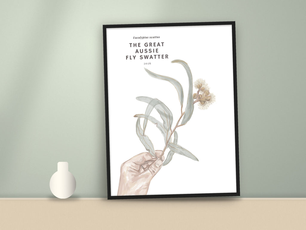 Framed eucalyptus wall art print with hand holding eucalyptus leaves and pale flowers