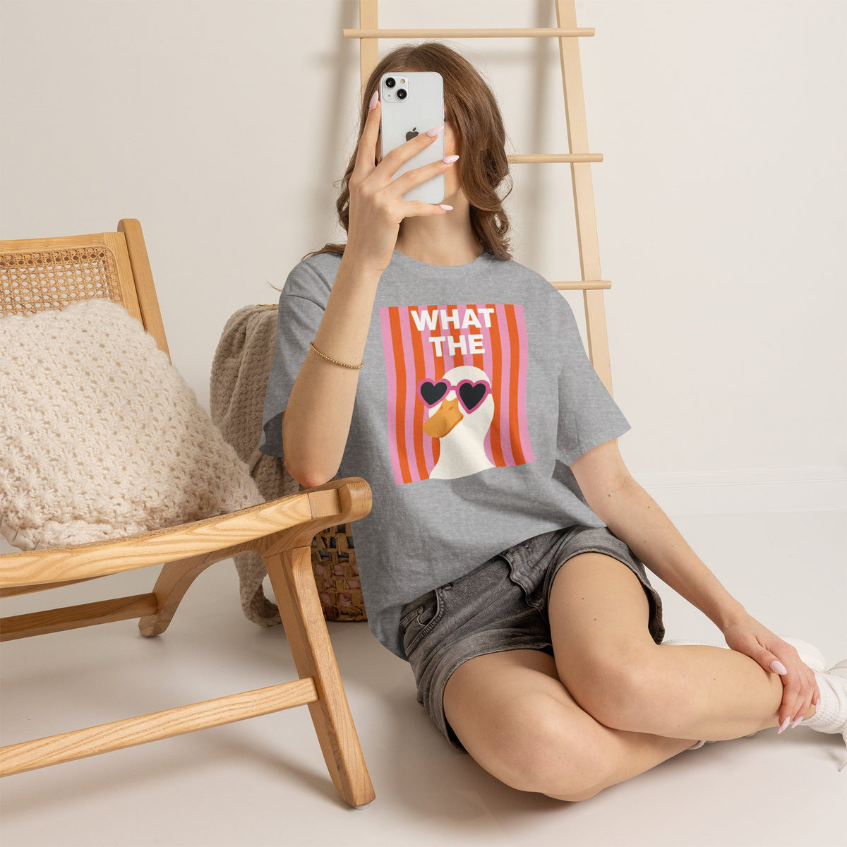 Gray crewneck T-shirt with “WHAT THE” duck graphic and heart sunglasses