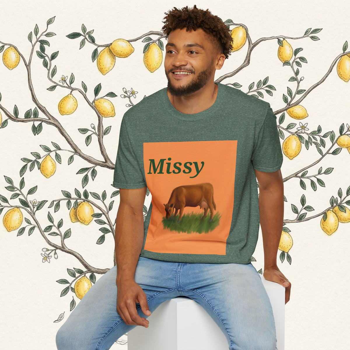 Green crewneck T-shirt with orange “Missy” cow graphic and grazing cow