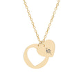 Gold heart cutout pendant necklace with engraved emblem, linked chain