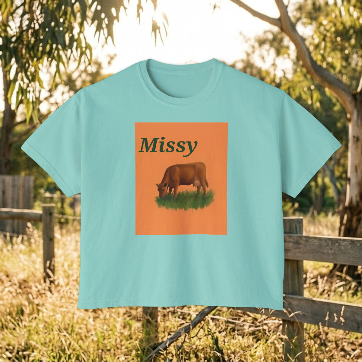 Teal boxy crewneck T-shirt with Missy grazing cow graphic