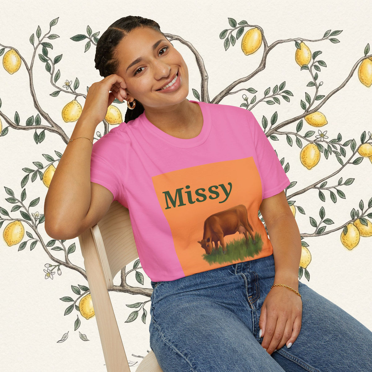 Pink crewneck t-shirt with orange panel graphic of grazing cow and “Missy” text