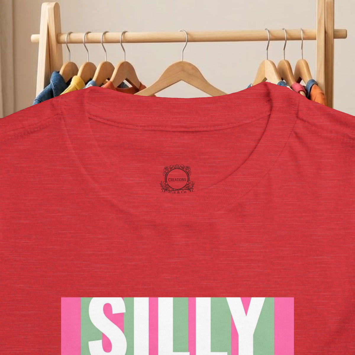 Toddler red tee close-up: small back logo and top of colorful “SILLY” print