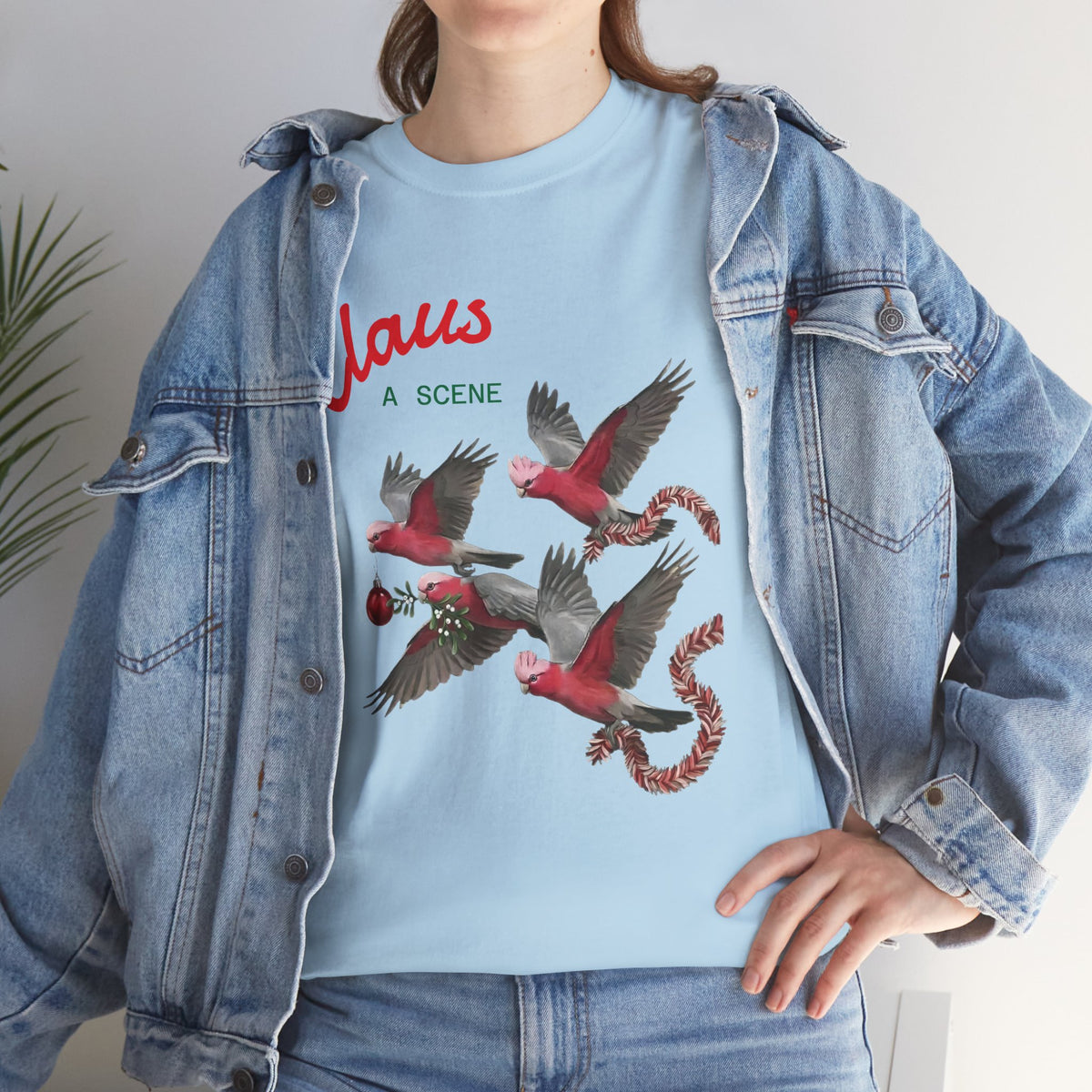 Light blue Christmas T-shirt with “Claus” text and red-and-gray bird graphic