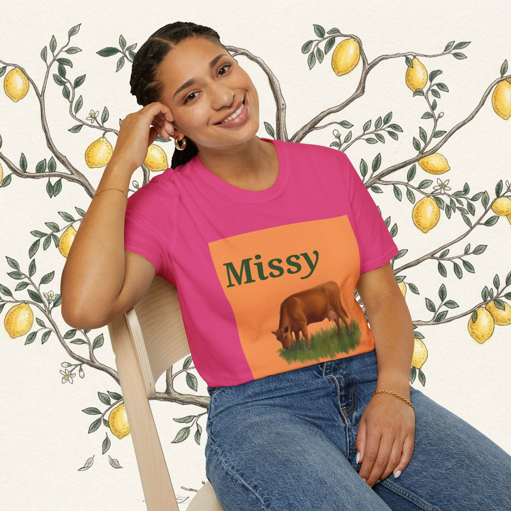 Pink crewneck t-shirt on model featuring orange grazing cow graphic and “Missy” text