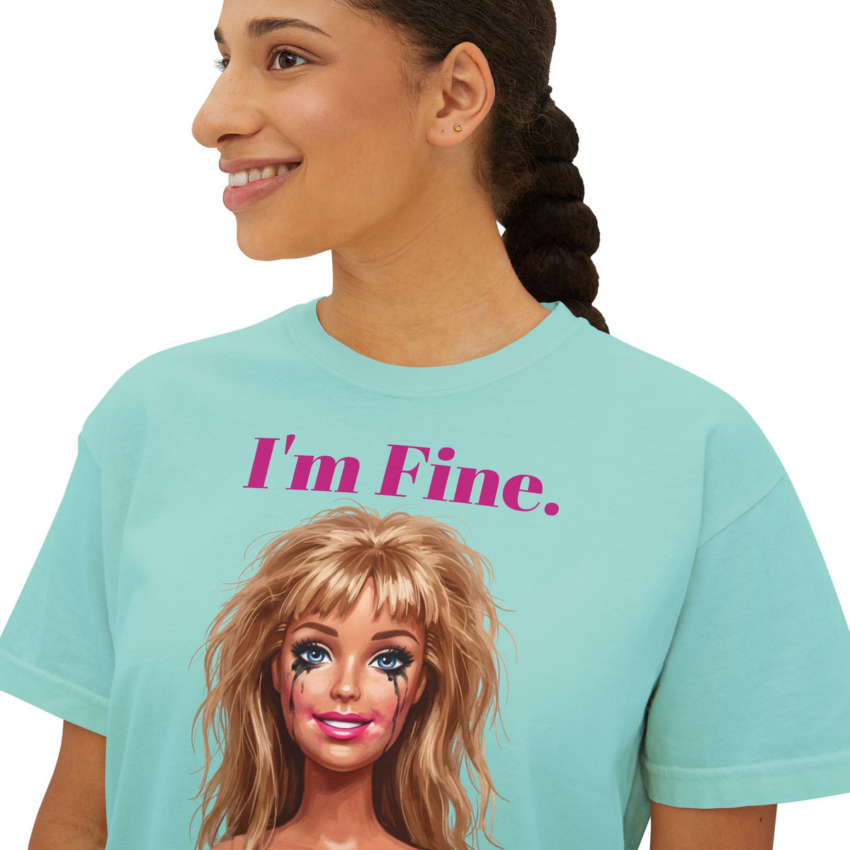 Boxy light aqua graphic tee with “I'm Fine.” text and doll face print, crew neck.