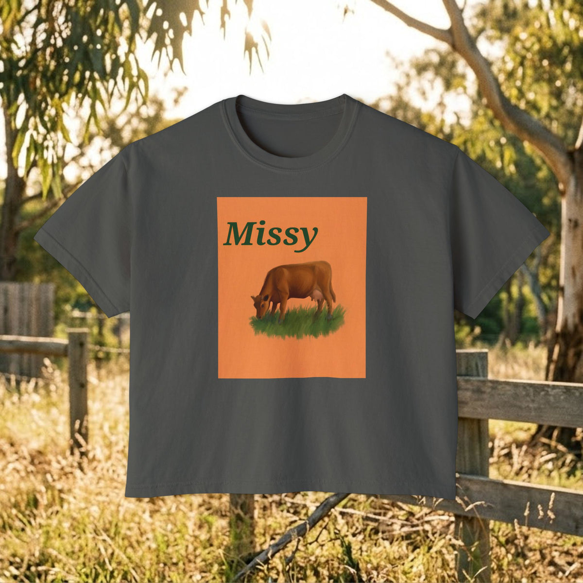 Dark gray boxy T-shirt with orange square cow graphic and “Missy” on front.