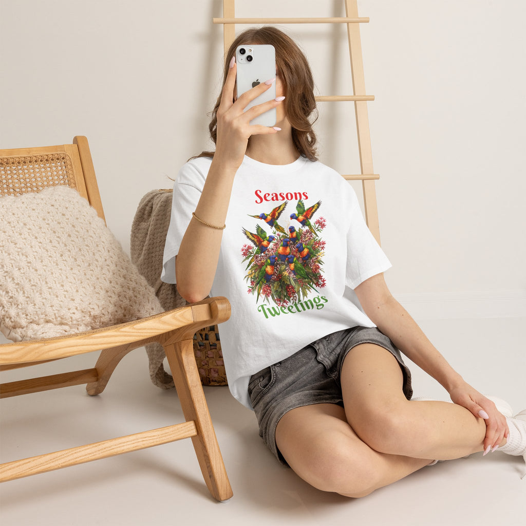 White T-shirt with 'Seasons Tweetings' bird floral graphic, shown from seated angle