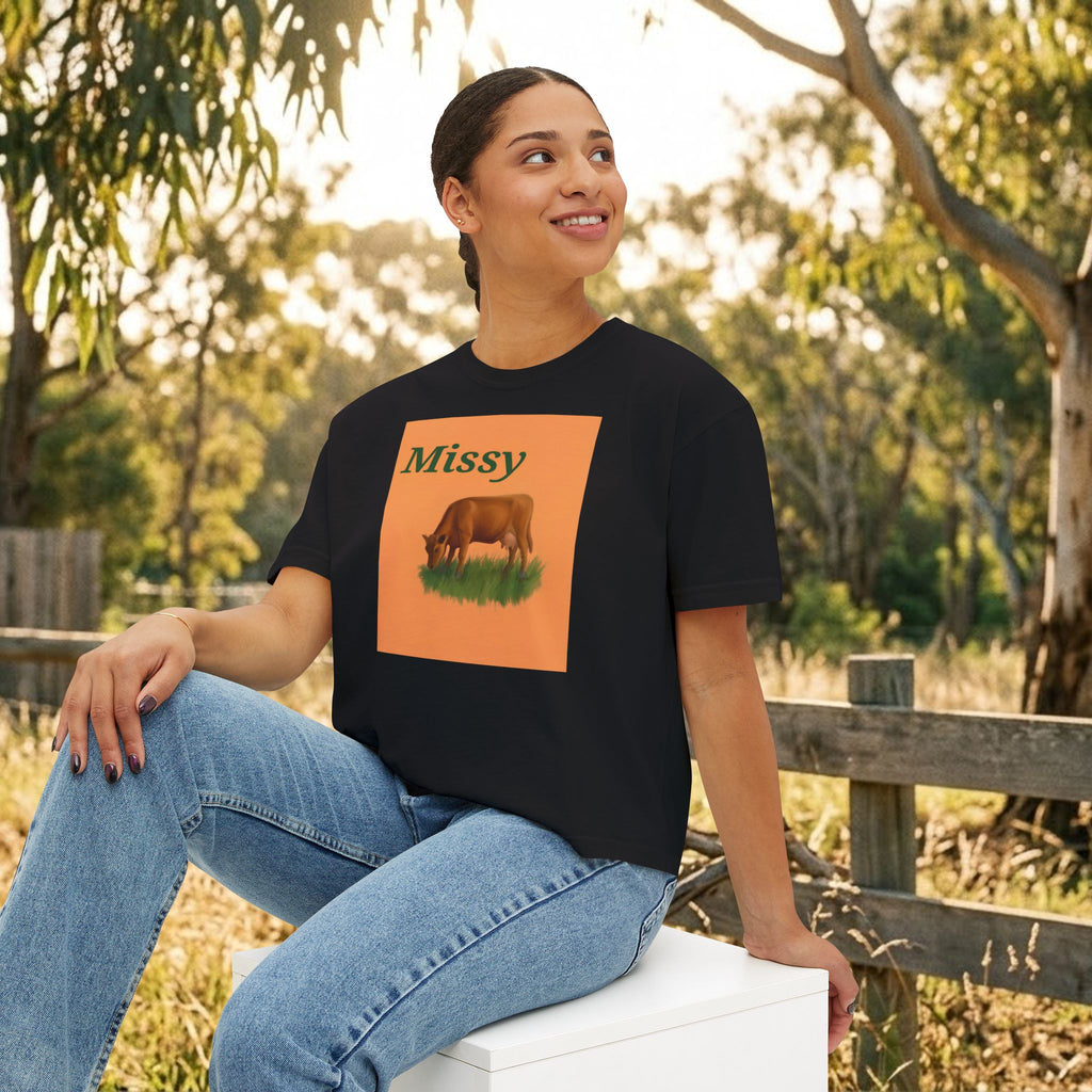Black boxy T-shirt with “Missy” cow graphic on the chest, front view.
