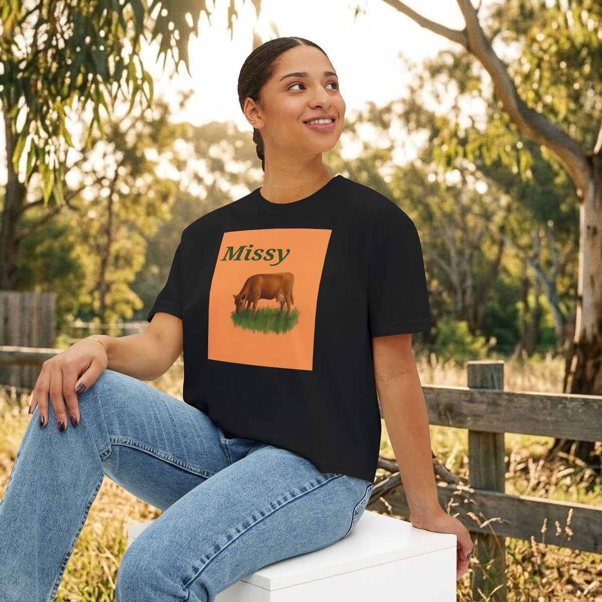 Black boxy T-shirt with “Missy” cow graphic on the chest, front view.