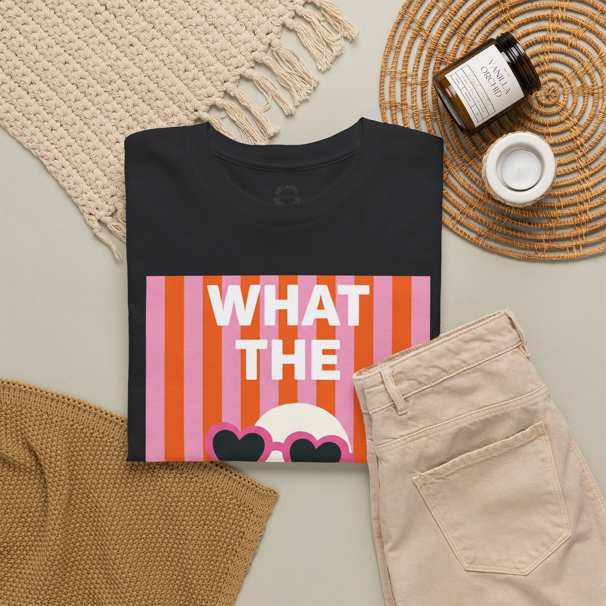 Black graphic cotton tee flat lay with "WHAT THE" heart sunglasses graphic