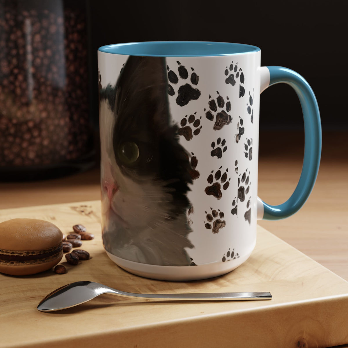Black cat face accent coffee mug with paw print pattern, white body, light blue handle