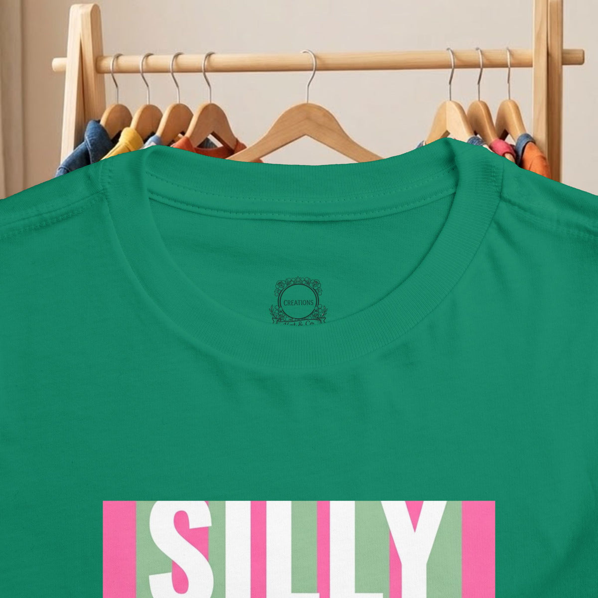 Green toddler T-shirt close-up: “SILLY” striped graphic with small logo