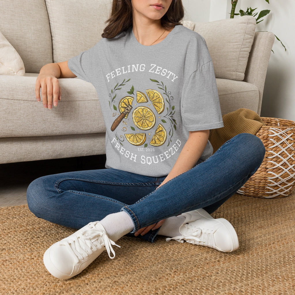 Light gray crewneck graphic tee with lemon slice print, worn while seated