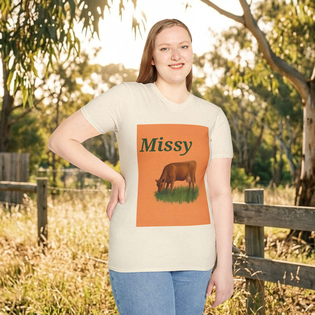 White crew-neck t-shirt featuring orange “Missy” and grazing cow graphic.