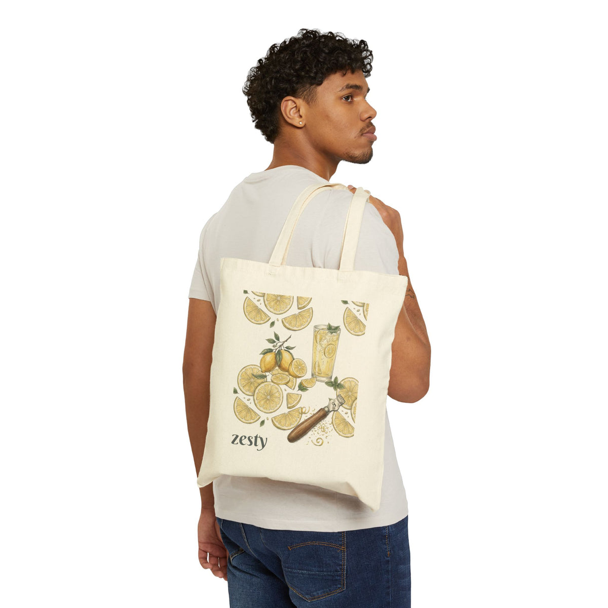 Cream canvas tote bag worn on back, featuring zesty lemon citrus front illustration