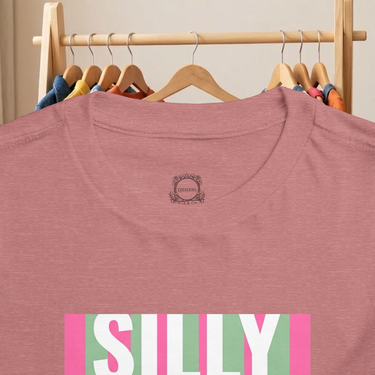 Toddler mauve T-shirt with small backneck logo and partial “SILLY” duck graphic